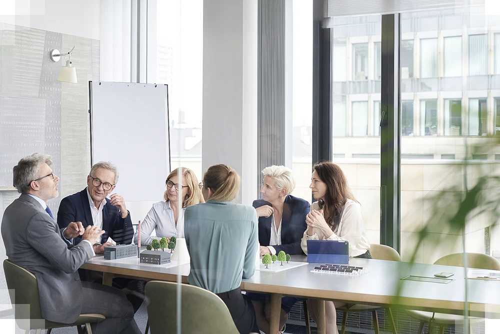 A photo of a group of individuals holding a business meeting in an office environment.